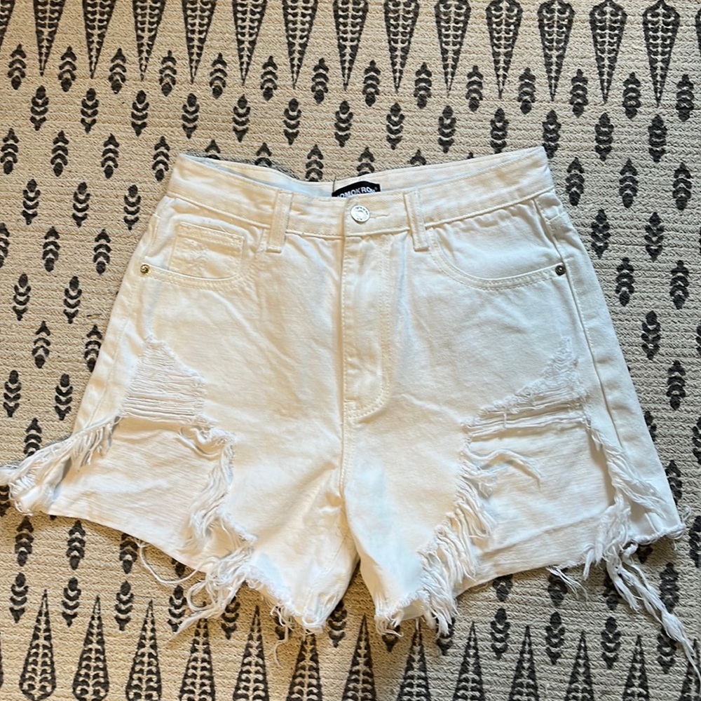 White cotton jean shorts with distressed feature in front.
